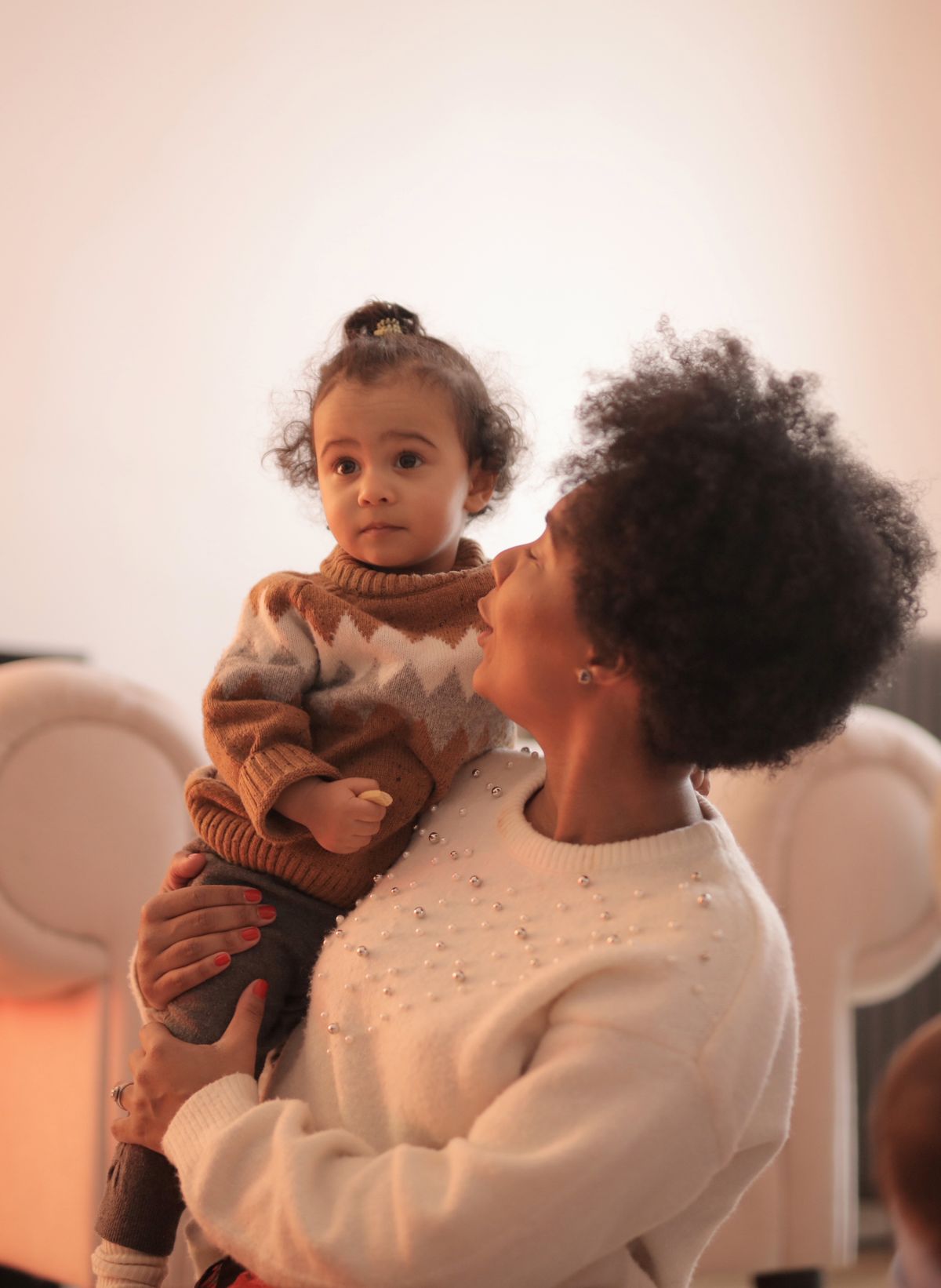 Mother carrying her baby in a bright nursery