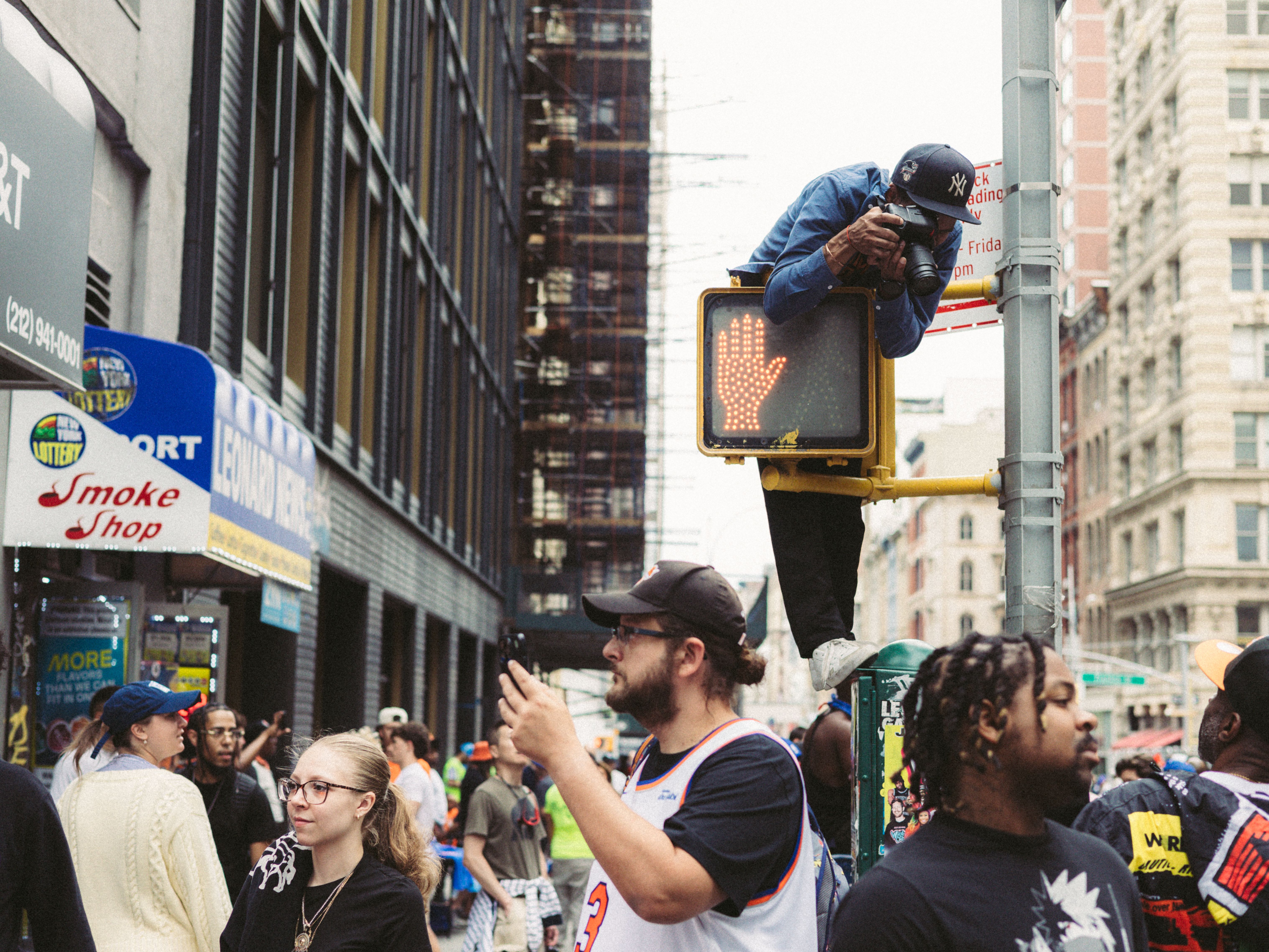 New York City street corner with bystanders filming on phones