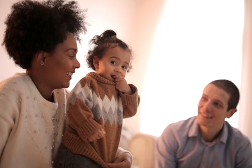 Woman in Brown Sweater Carrying Baby in Brown Sweater