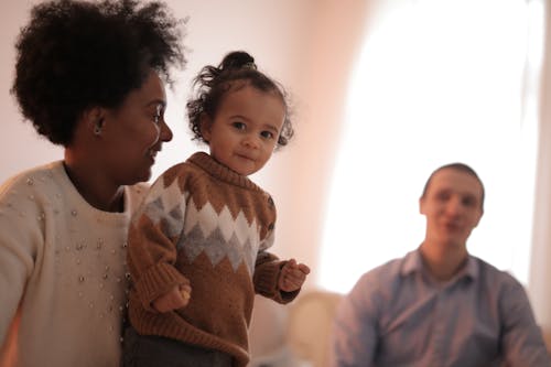 Free Woman in Brown Sweater Carrying Child in Brown Sweater Stock Photo