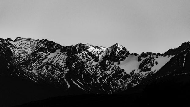 Black and white photo of snow-covered Andes in Ushuaia, Argentina at dusk.