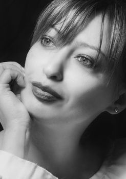 Artistic black and white portrait of an elegant woman with thoughtful expression.