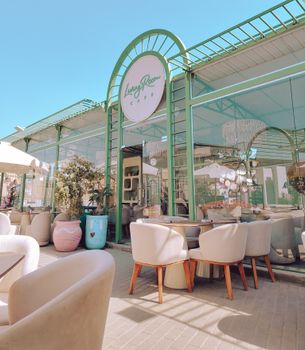 Charming outdoor cafe with modern design and comfortable seating under a clear blue sky.