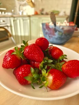Ripe strawberries in a home kitchen setting, evoking freshness and homeliness.