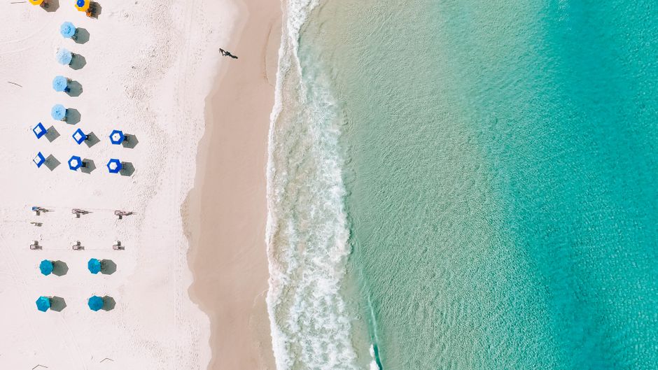 Spectacular Miami Helicopter Tour Hard Rock and Beach Review: Iconic Views from 20 Minutes in the Sky Review 2026 - A stunning aerial view of a pristine beach with colorful umbrellas and turquoise waters.