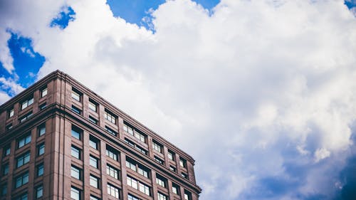 무료 흰 구름 아래 갈색 건물 스톡 사진
