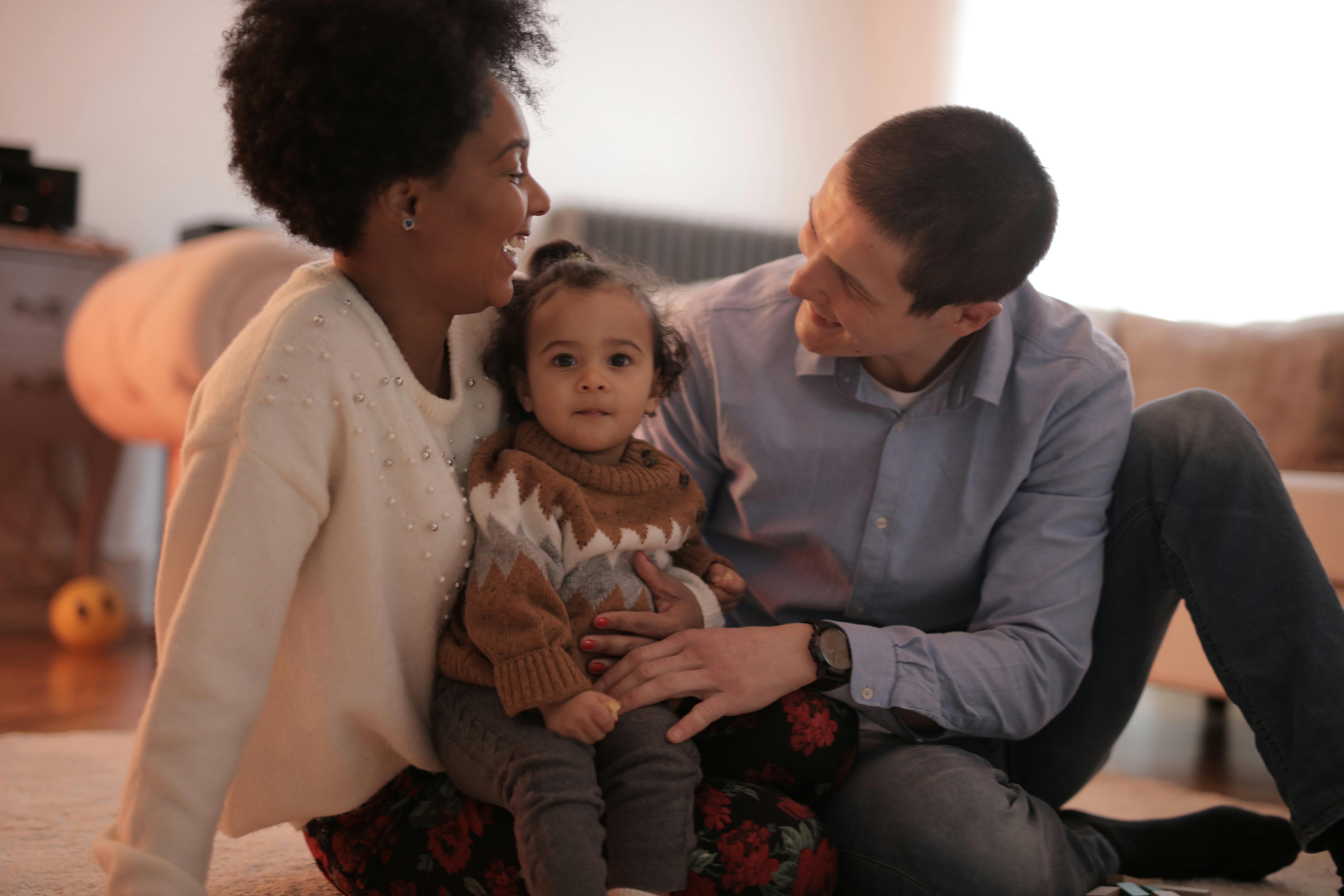 photo of man and woman sitting with their child