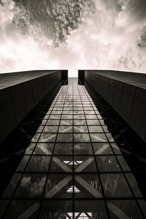 Free A striking view of a modern skyscraper in Minneapolis reaching into a cloudy sky, captured in monochrome. Stock Photo