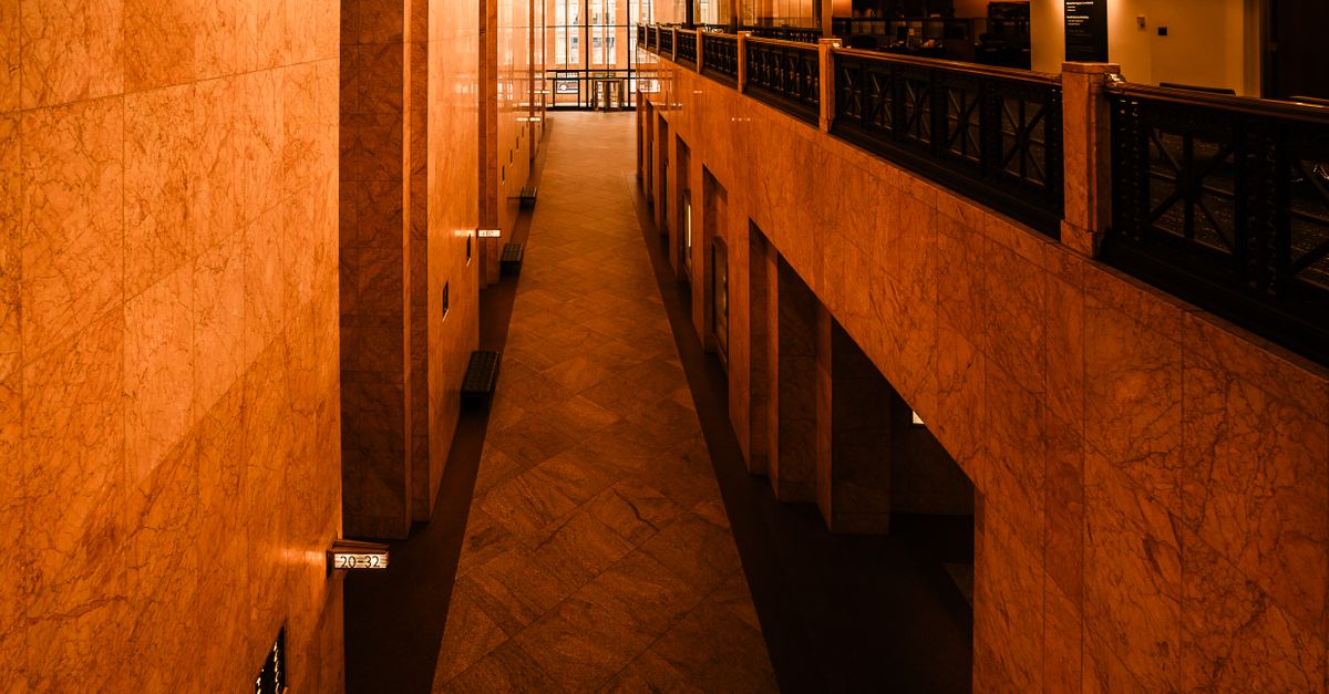 A warm, elegant interior view of a marble floored hallway in a Minneapolis building, showcasing architectural design.