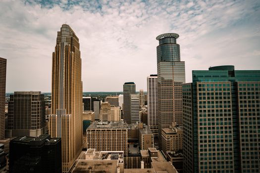 Aerial view of the Minneapolis skyline highlighting its diverse architecture under a cloudy sky.