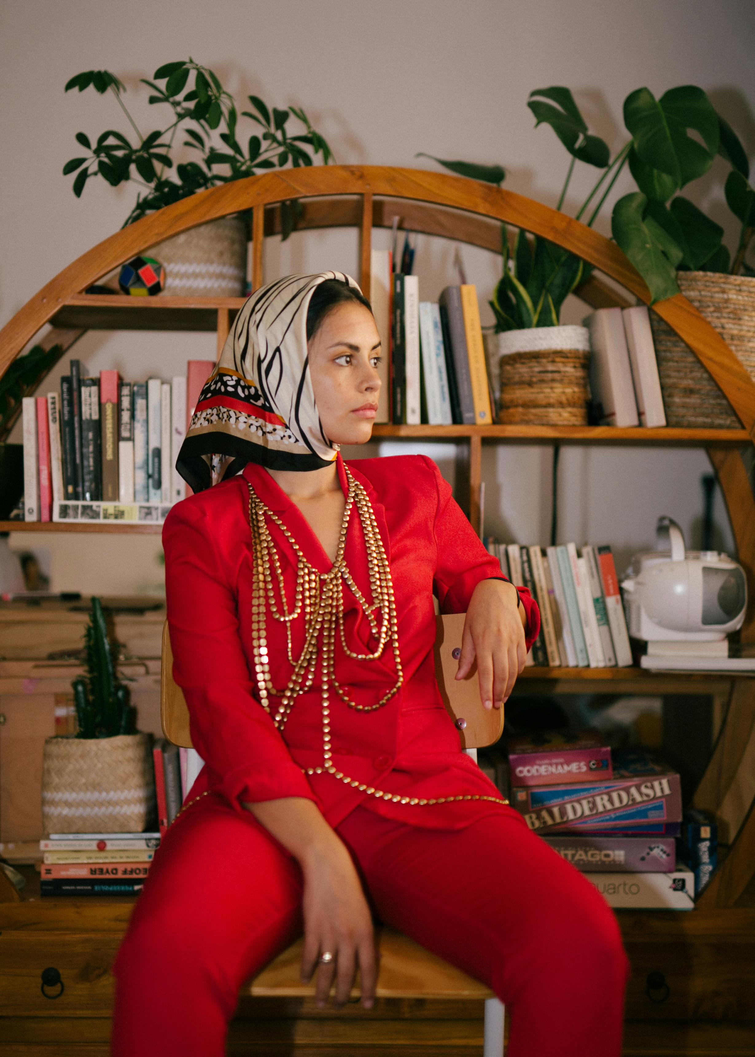 trendy ethnic woman in fashionable clothes at home