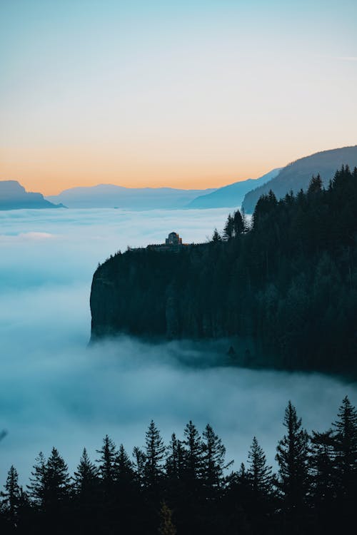 Picturesque view of mountains on foggy day at colorful sunset