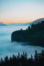 Picturesque view of mountains on foggy day at colorful sunset