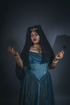 Dramatic portrait of a woman in a Victorian-style gown and veil, holding a rose.. dramatic, portrait, woman