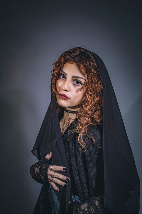 Free Dramatic portrait of a woman with red hair in a black veil, exuding a Gothic vibe. Stock Photo