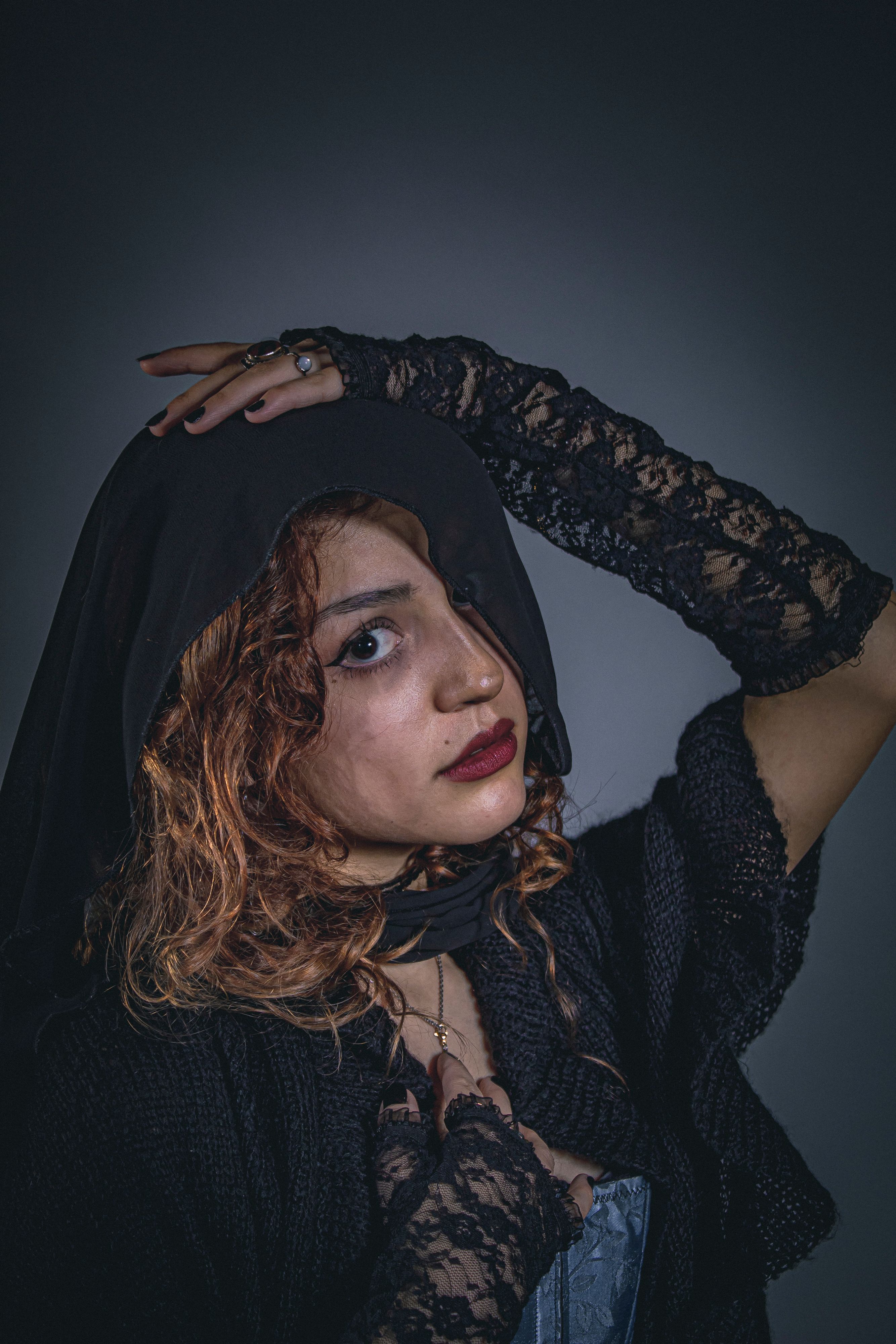 Dramatic portrait of a woman in lace and veil with Victorian style elements.