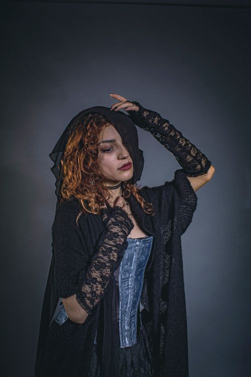 Free A moody portrait of a woman in Victorian-style clothing with lace and a corset. Stock Photo