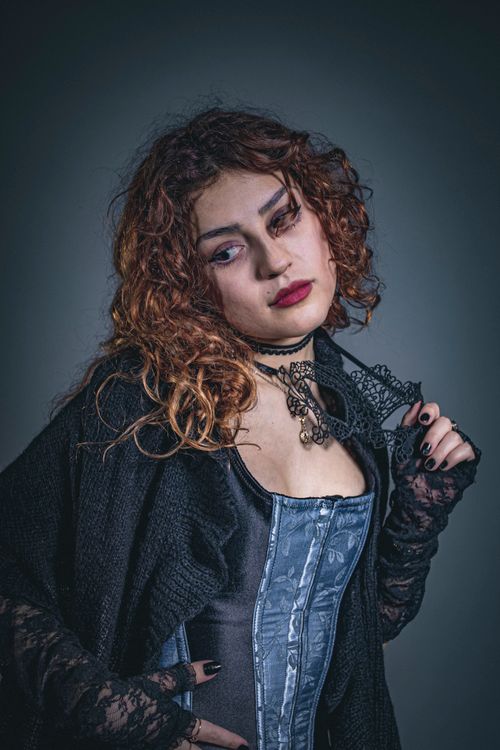 Free A moody portrait of a woman in gothic Victorian fashion with curly hair and choker necklace. Stock Photo