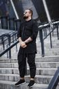 Man in Black Shirt and Black Pants Standing on Gray Concrete Stairs