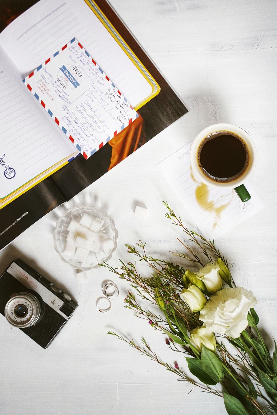 Coffee flowers and notebook styled on a desk
