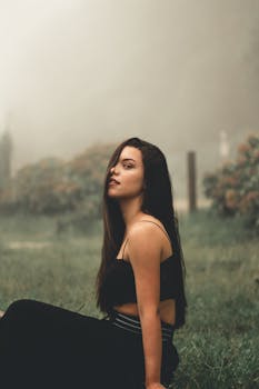 一个女人坐在雾蒙蒙的花园里，显得自信而宁静