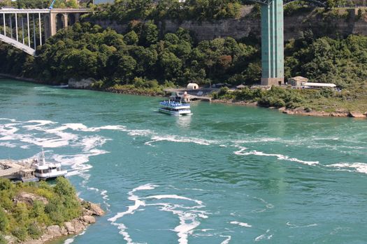 A vibrant view of Niagara Falls showcasing tour boats and lush greenery.