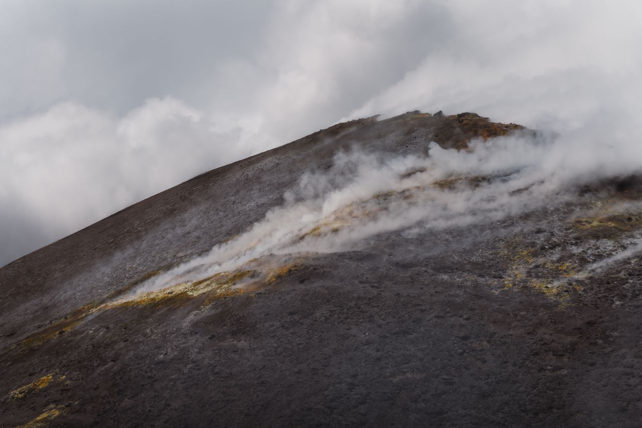 steam rises from the volcanic slope of mount etna in sicily