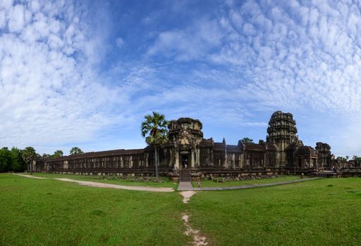 Wide-angle view of Angkor Wat temple under a vibrant sky in Cambodia, capturing its grandeur.