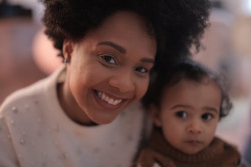 Крупным планом фото женщины, улыбающейся рядом с ребенком