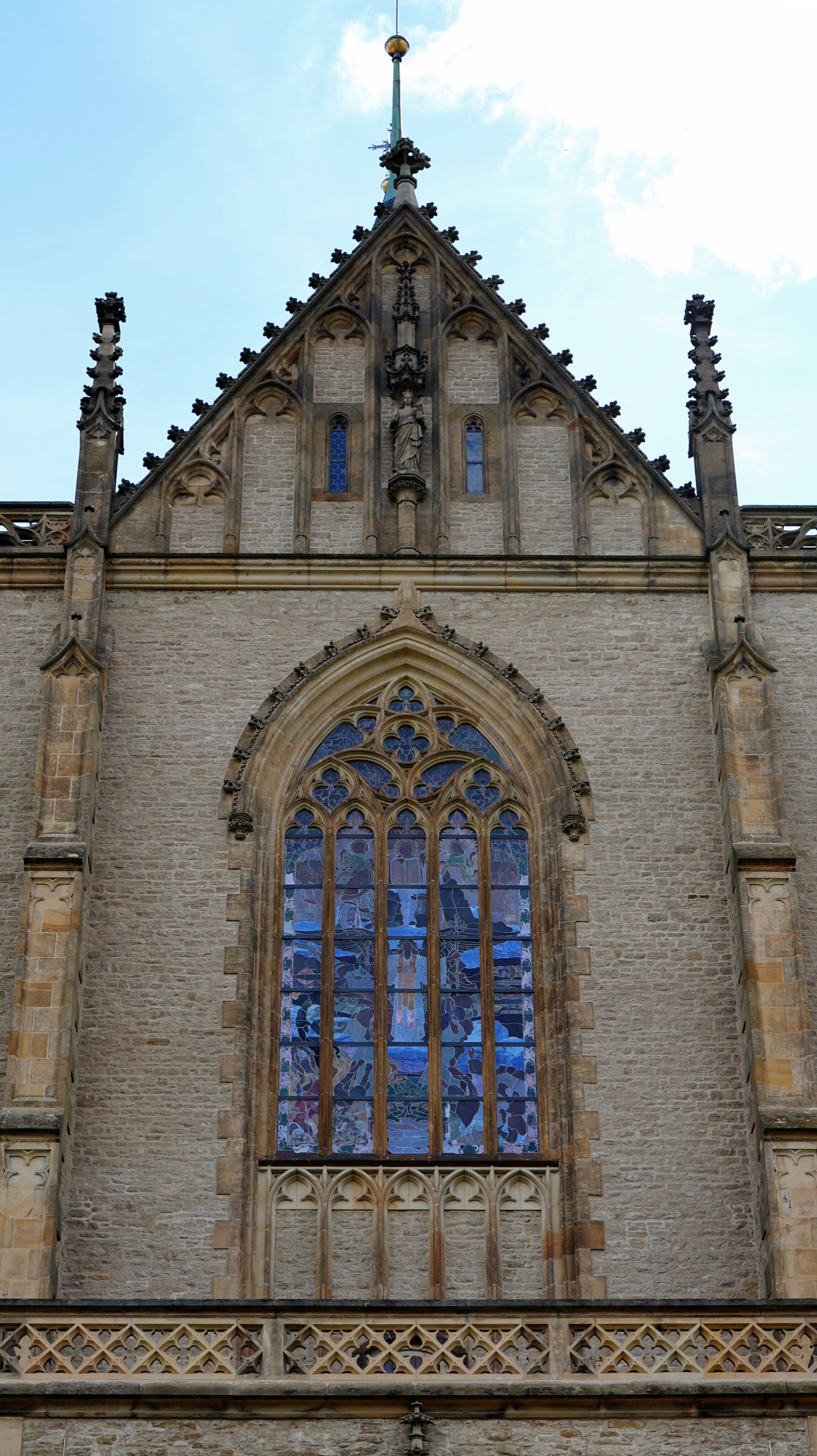 Detailed view of a Gothic cathedral window in Kutná Hora, showcasing ornate architecture and stained glass.