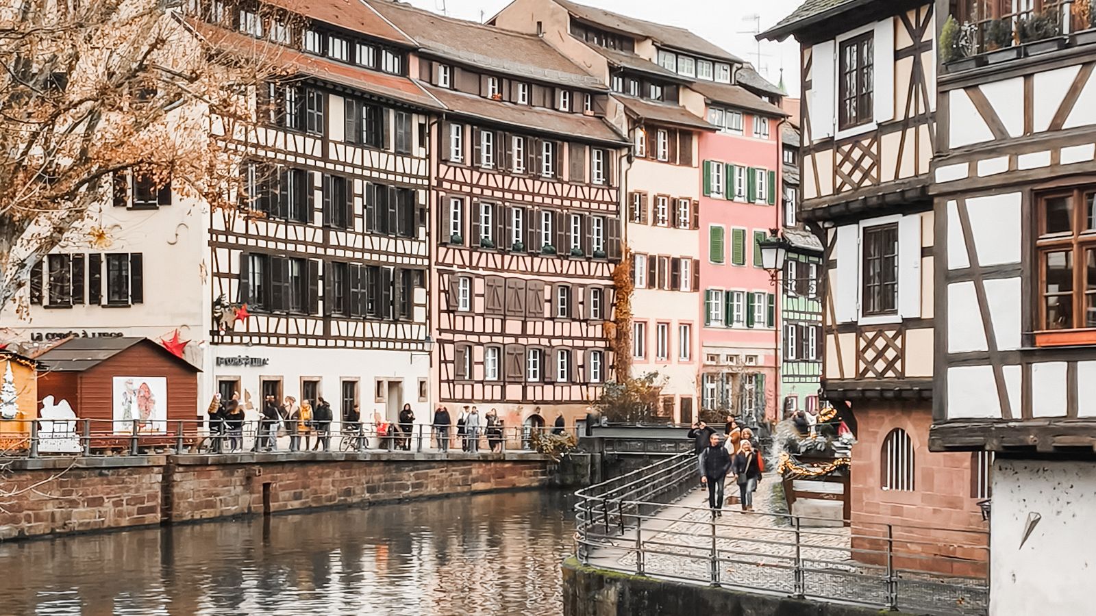 Maisons à colombages alignées le long d'un canal calme, au cœur historique de Strasbourg.