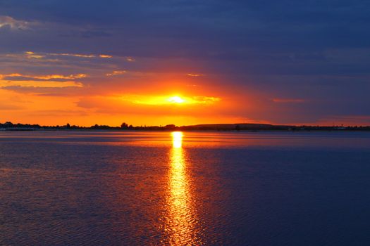 Capture the breathtaking sunset over Bucharest Lake with vibrant colors reflecting on the water.