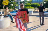 Protesters in Baltimore celebrate Juneteenth with signs and American flag, promoting democracy and freedom.