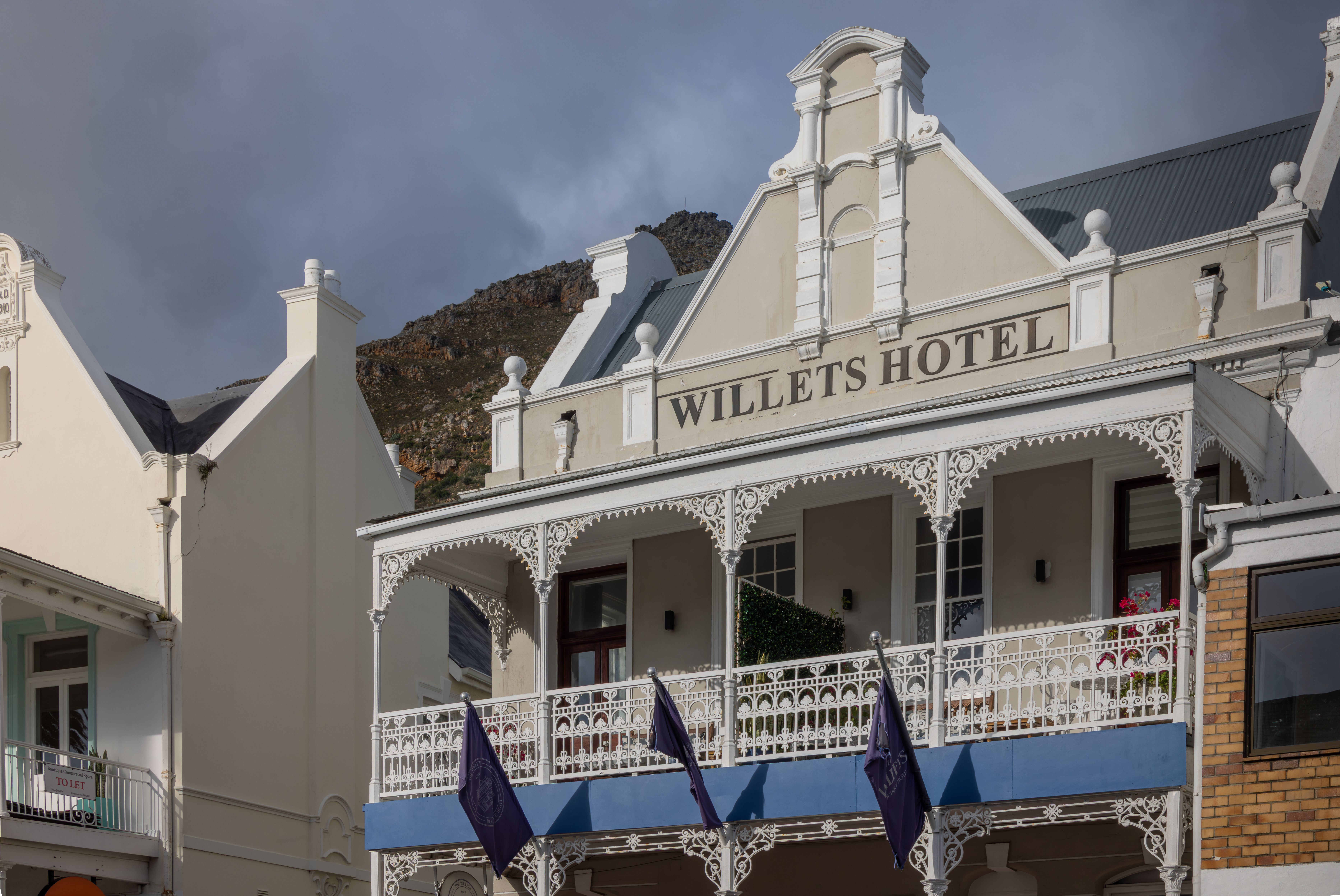 Elegant Victorian-style Willetts Hotel with intricate balconies under a cloudy sky.