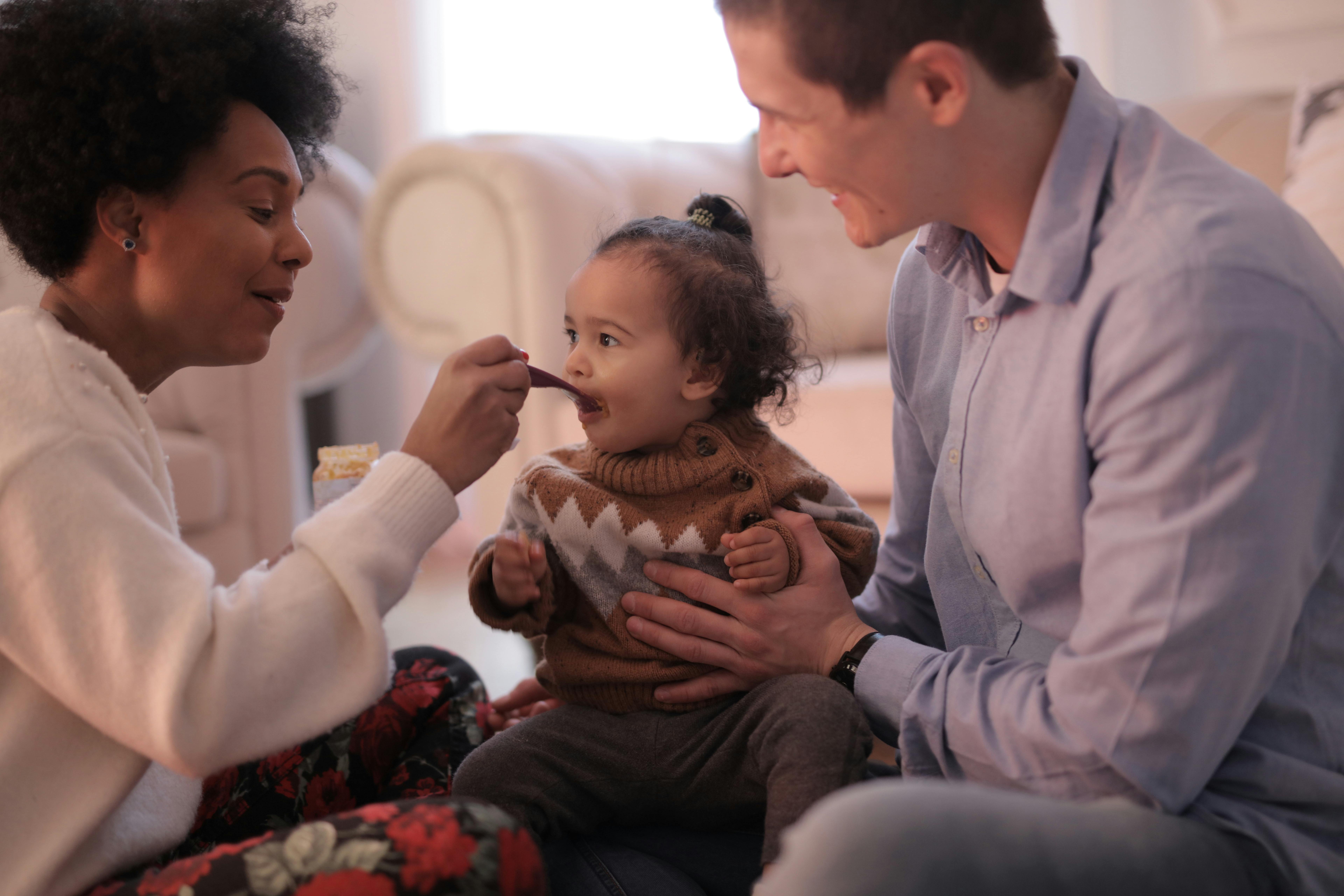 photo of woman feeding her child