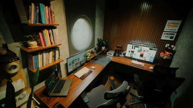 A modern home office featuring a wooden desk, dual monitors, and shelves with books.