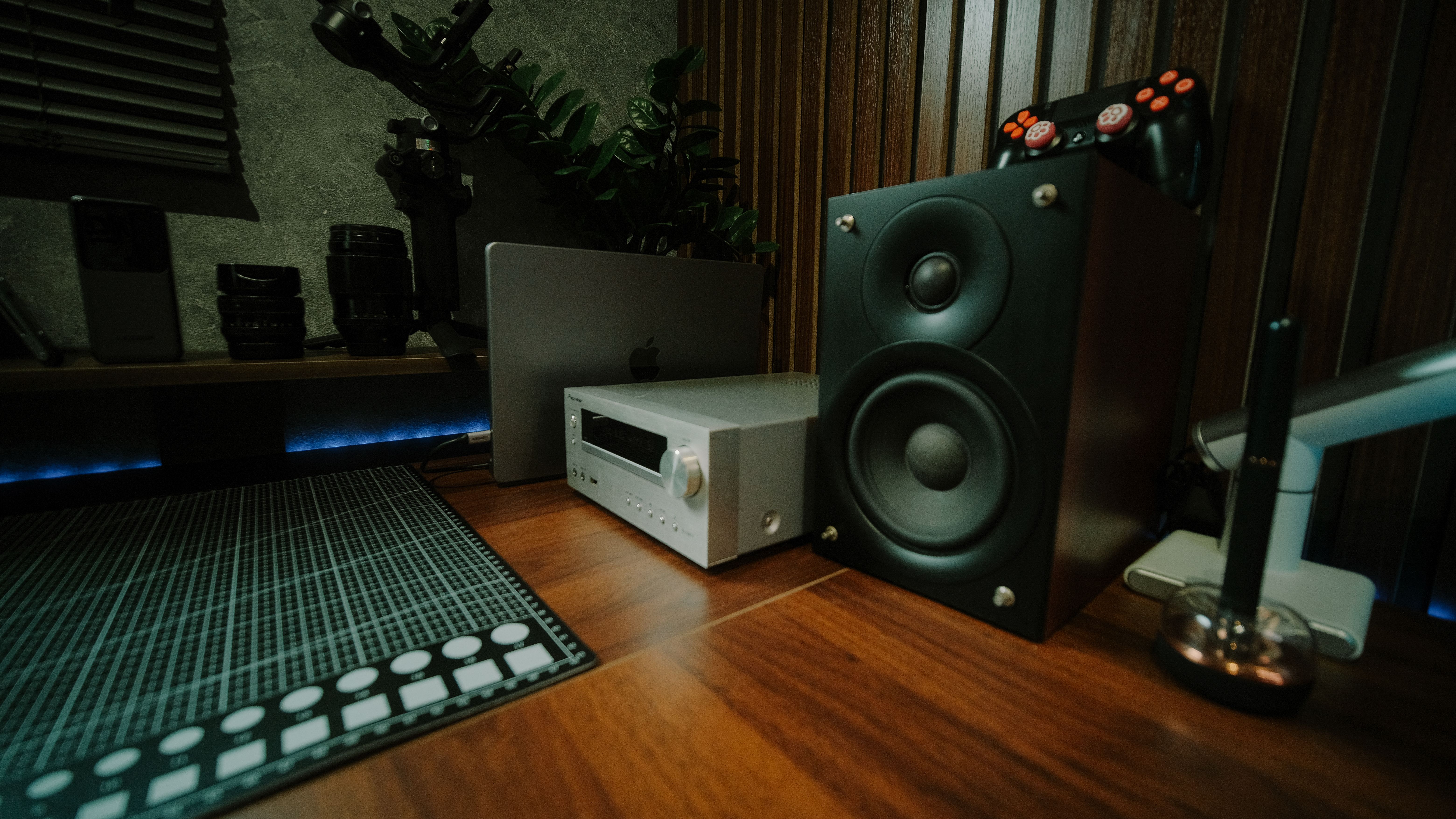 A stylish home office featuring audio equipment and modern gadgets on a wooden desk.