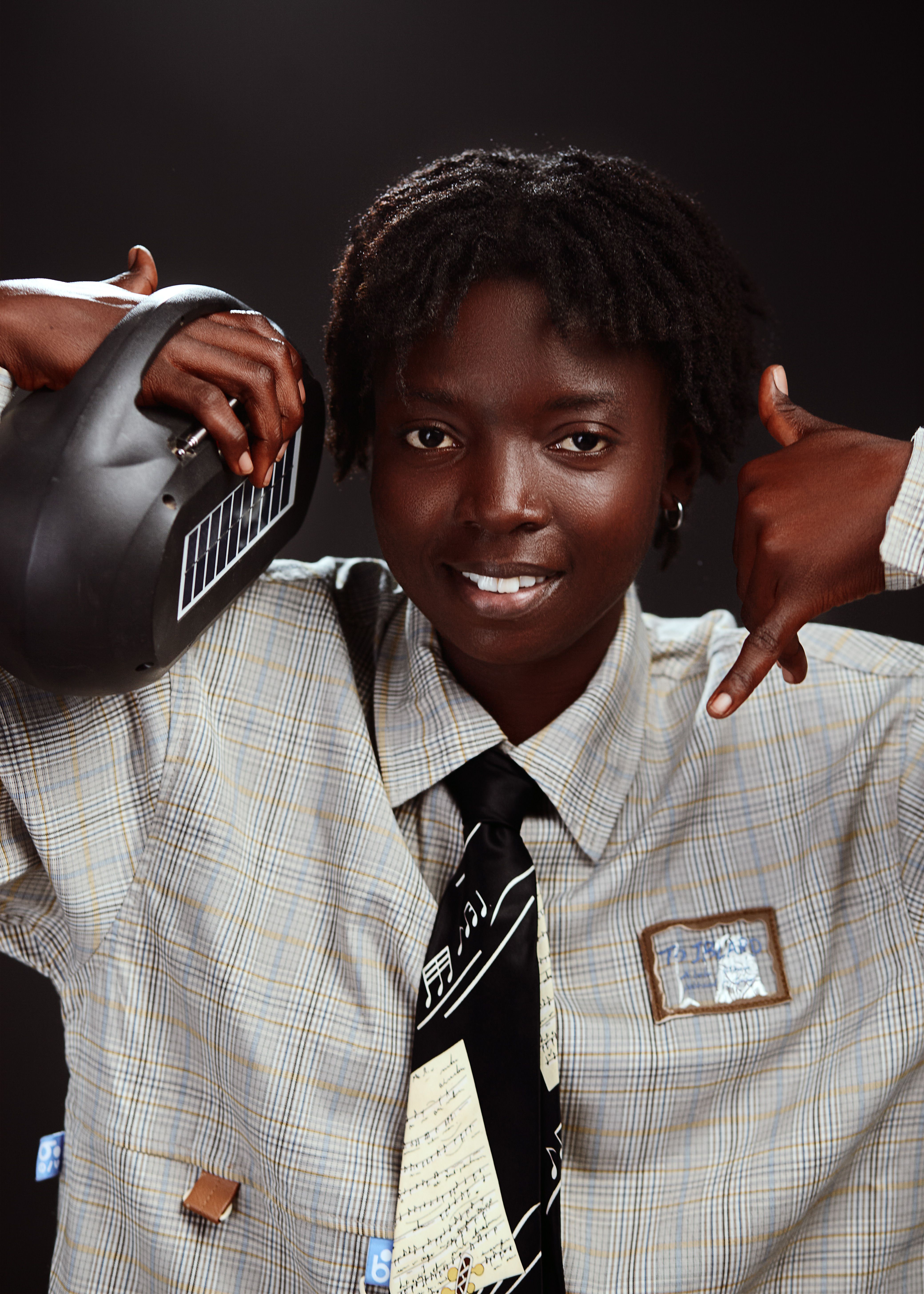 Portrait of a young African adult with unique fashion holding a boombox.
