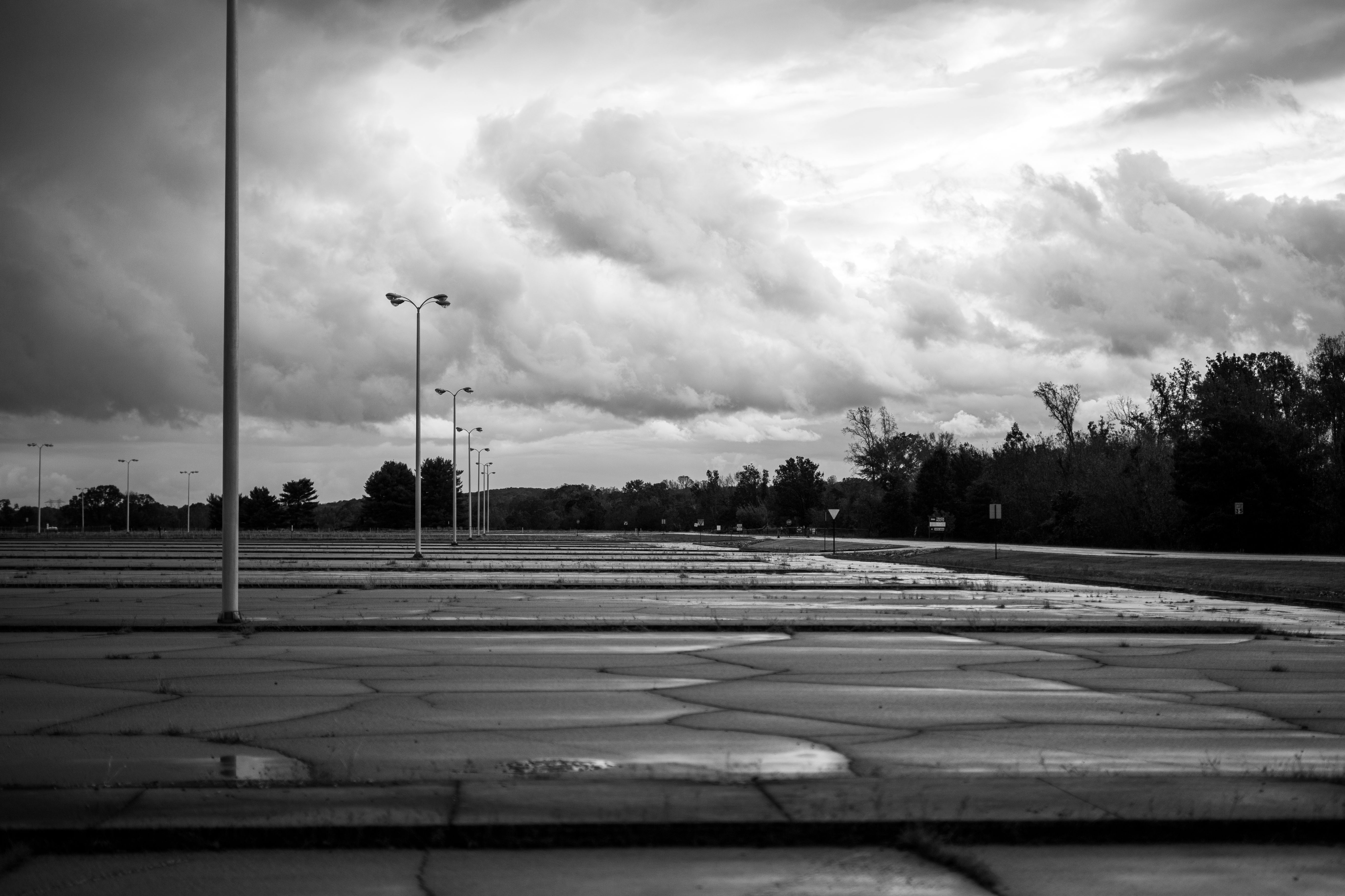 A moody, cloudy sky over an abandoned parking lot, enhancing solitude.