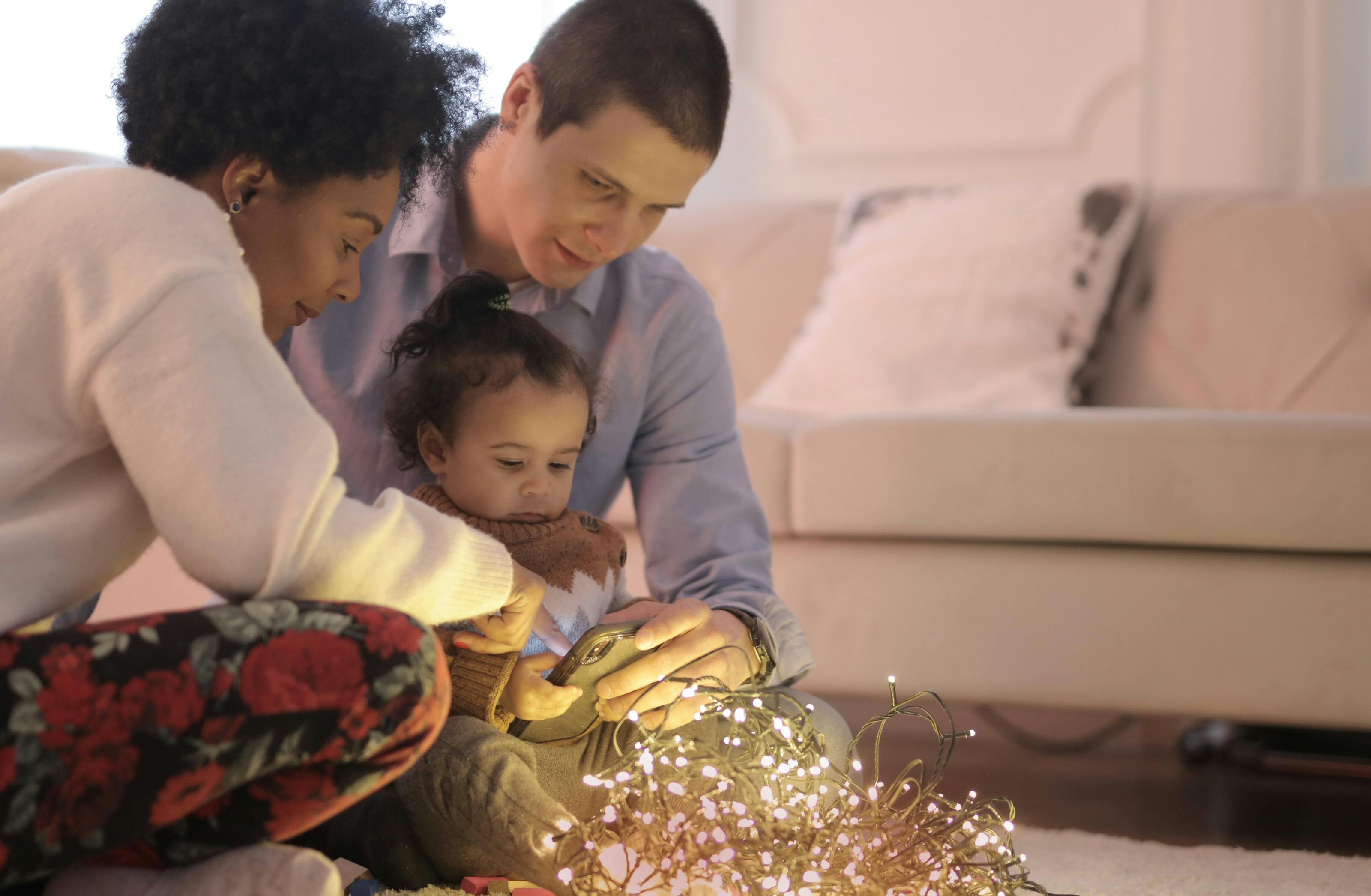 photo of family sitting near string lights