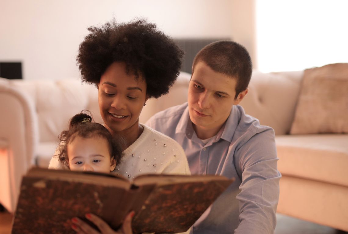 Happy family sharing story time together in a comfortable living room