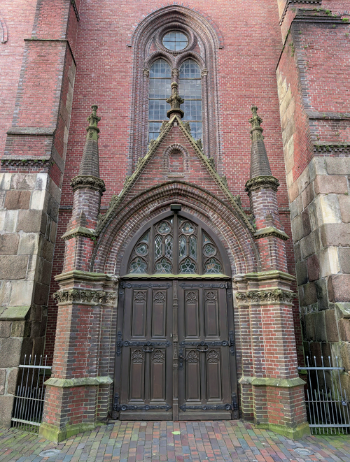 Free Detailed view of a Gothic church entrance with a rich brick facade. Stock Photo