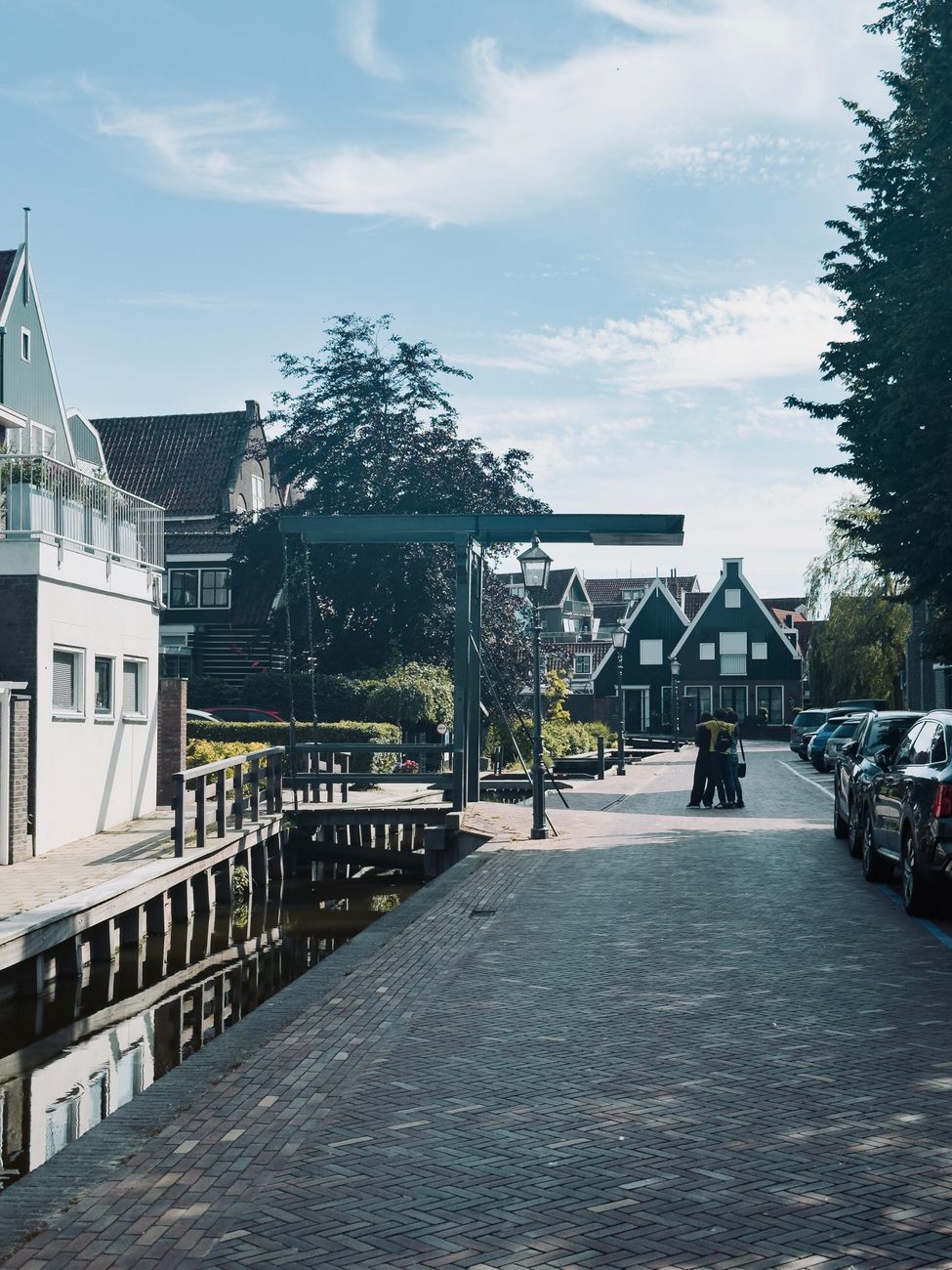 Charmant tafereel van een rustige Nederlandse dorpsstraat met traditionele huizen en een serene gracht.