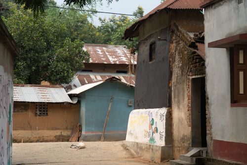 Free A rustic village street in Santiniketan, West Bengal featuring traditional huts and colorful walls. Stock Photo