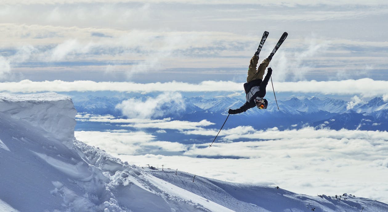 Gratis Esquiador Irreconocible Realizando Truco Boca Abajo En Montañas Nevadas Foto de stock