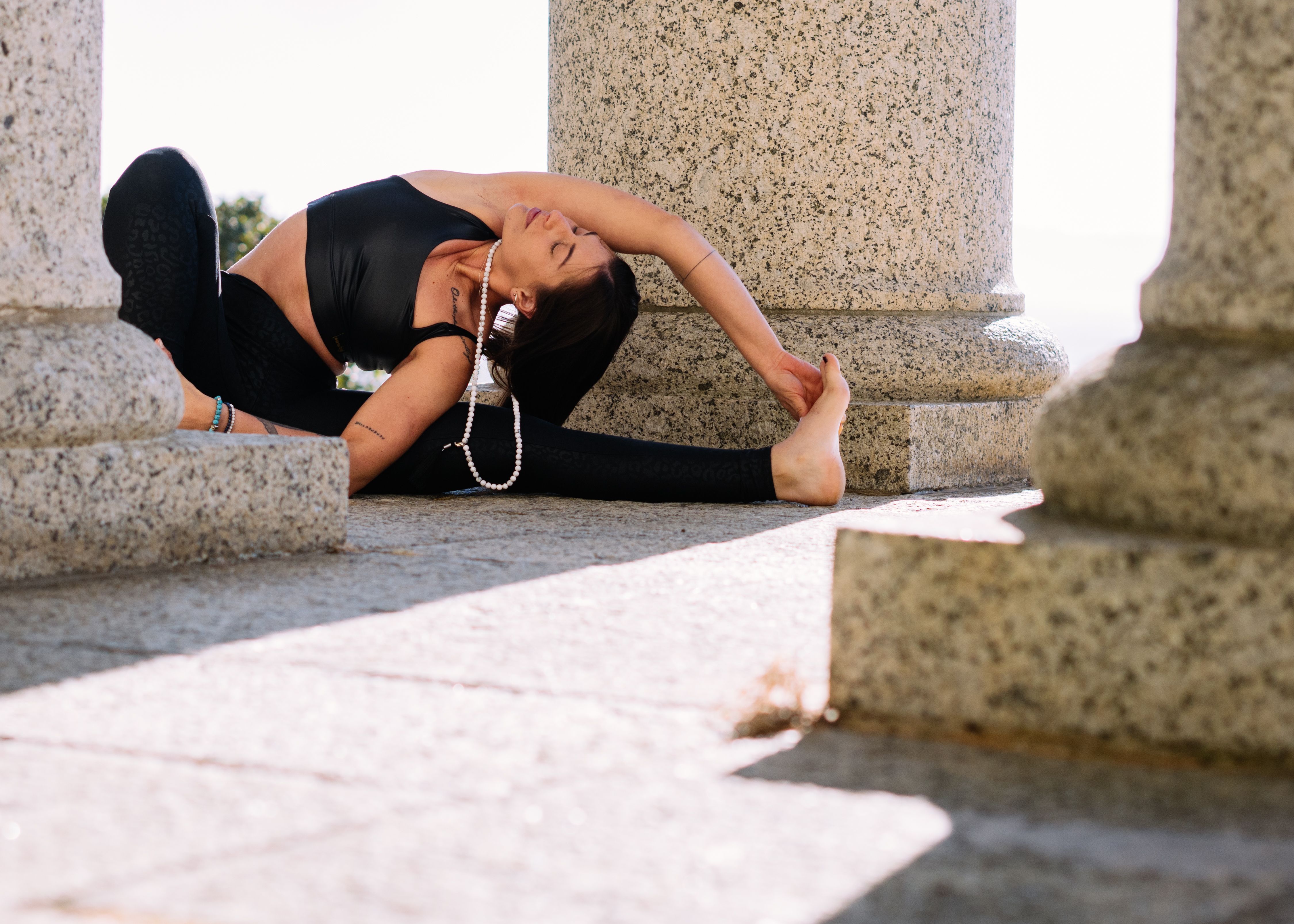 Woman in Black Tank Top and Black Leggings Stretching · Free Stock Photo