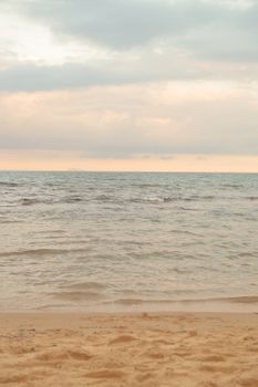 A tranquil beach scene with gentle waves and an enchanting sunset sky.