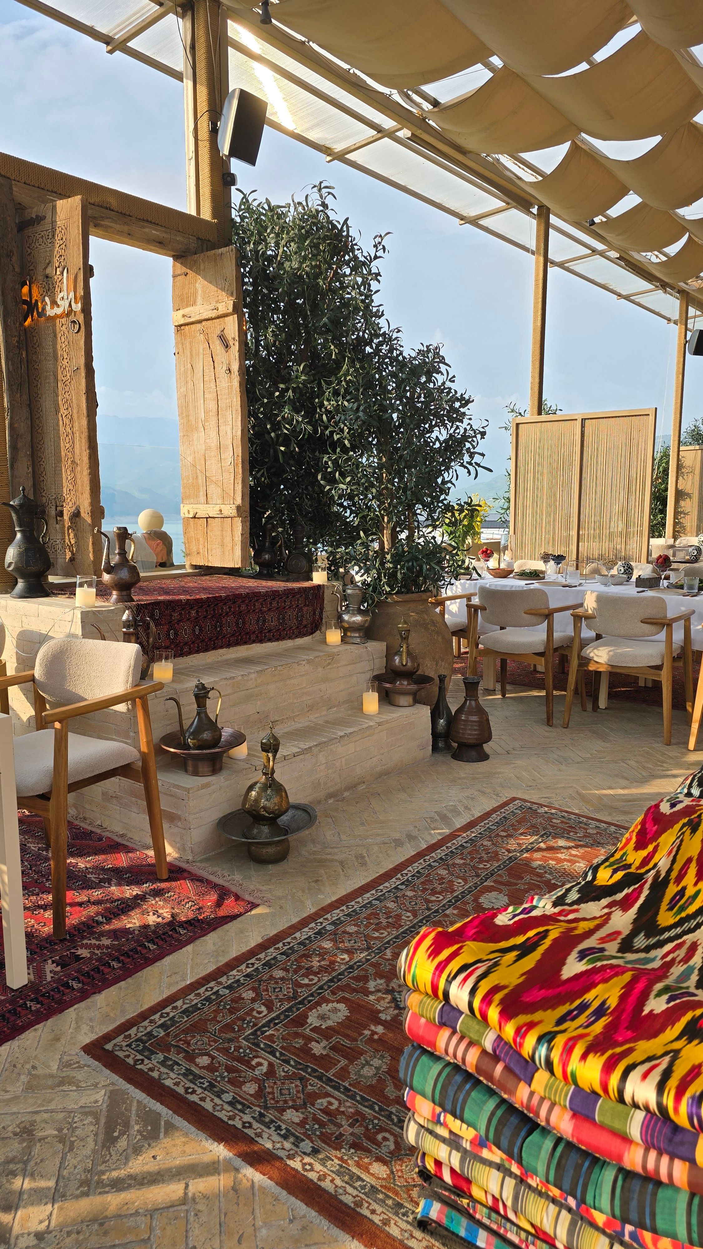 Charming outdoor dining area with vintage rugs and exotic decor, perfect for a cozy gathering.