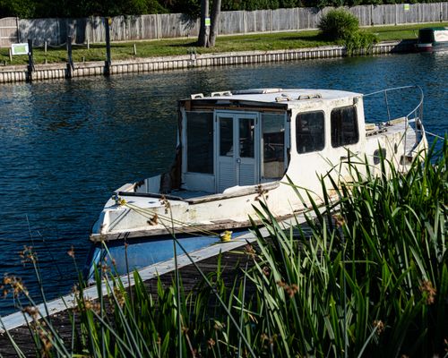 Free A vintage boat anchored by the riverside in Sonning, England, surrounded by lush greenery. Stock Photo