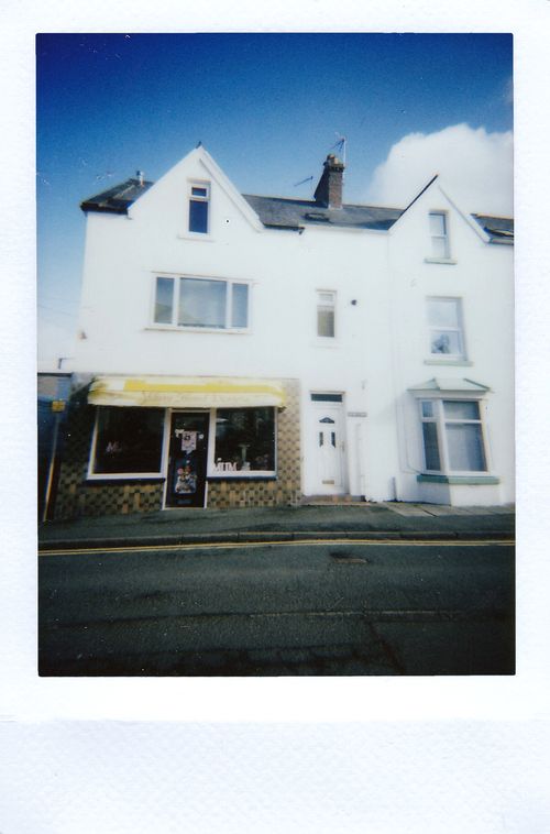 Free Polaroid photo of an urban residential building with a store front. Features a vintage style. Stock Photo